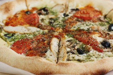 Tavuk, domates ve peynirli İtalyan pizzası.