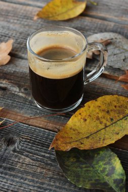 Espresso kahve ve sonbahar yaprakları masada. 