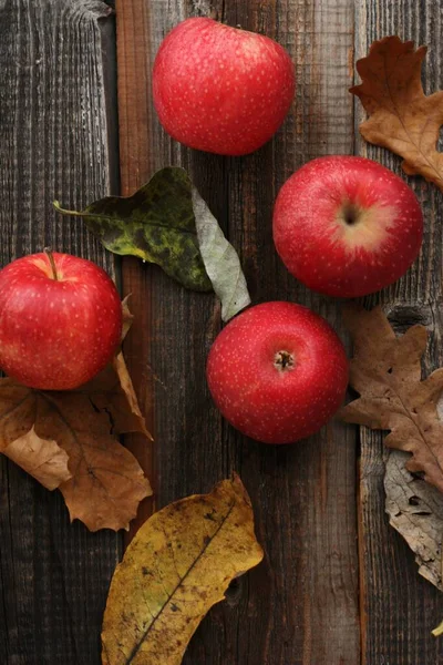 Ζουμερά Κόκκινα Μήλα Και Φθινοπωρινά Φύλλα Στο Τραπέζι — Φωτογραφία Αρχείου