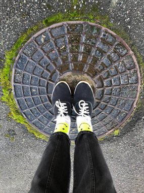 Kapakta siyah spor ayakkabılı bacaklar.