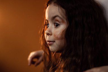 Parlak kahverengi gözlü kahverengi saçlı bir kızın portresi.