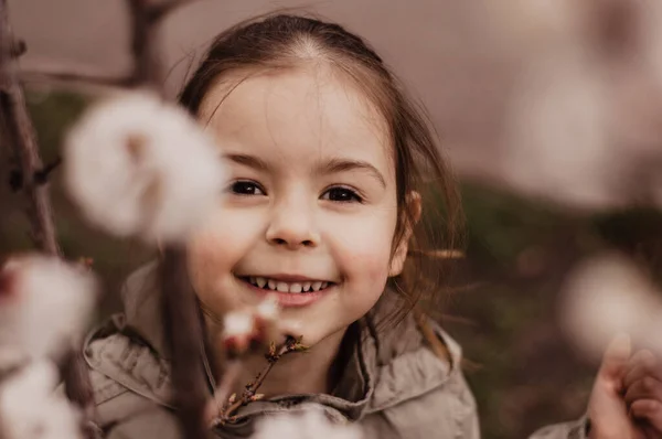 Dziewczynka Wąchanie Moreli Kwiaty Gałęzi Drzewa — Zdjęcie stockowe