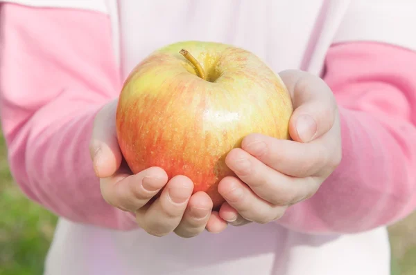 Manzana en las manos de los niños — Foto de Stock