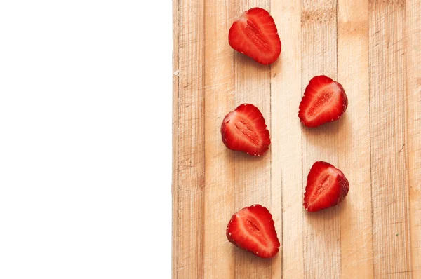 Fraises tranchées sur une planche de bois — Photo