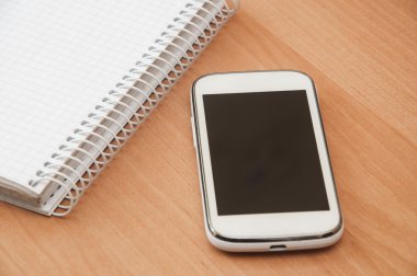 defter ve masanın üstünde hareket eden telefon