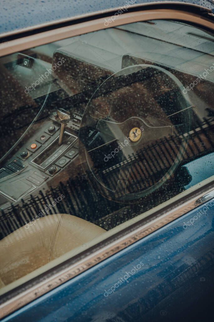 Bath, UK - October 04, 2020: View through the window of streering wheel and dashboard of Ferrari 412, a rare model designed by Pininfarina and produced between 1972 and 1989.