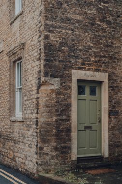 Frome, İngiltere - 07 Ekim 2020: Somerset 'in pazar ve bağımsız dükkanlarıyla ünlü bir pazar kasabası olan Frome' da geleneksel bir taş evin yeşil ön kapısı.