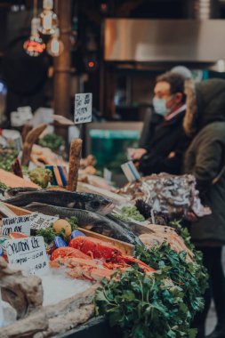 Londra, İngiltere - 19 Kasım 2020: Borough Market 'teki bir balıkçıda taze balık satışı, Londra' nın en büyük ve en eski gıda pazarlarından biri, arka planda müşteri, seçici odaklı.