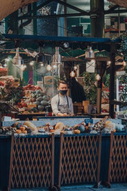 Londra, İngiltere - 19 Kasım 2020: Londra, İngiltere 'deki en büyük ve en eski gıda pazarlarından biri olan Borough Market' teki gıda standında koruyucu yüz maskesi takan çalışanlar.