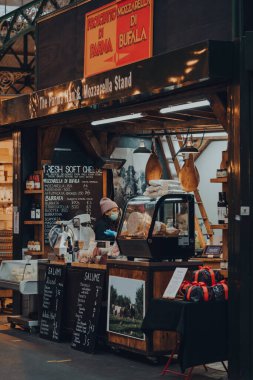 Londra, İngiltere - 19 Kasım 2020: Londra, İngiltere 'deki en büyük ve en eski gıda pazarlarından biri olan Borough Market' teki Parma Ham ve Mozarella standında koruyucu yüz maskesi takan satıcı.