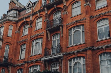 Mayfair, Londra, İngiltere 'de balkonları olan geleneksel kırmızı tuğlalı apartman bloğunun alçak açılı görüntüsü.
