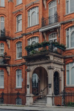 Londra, İngiltere - 5 Aralık 2020: Mayfair 'deki geleneksel kırmızı tuğlalı apartman bloğunun girişi, Londra' nın Batı ucunda, Westminster Borough şehrinin varlıklı bir bölgesi..
