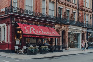 Londra, İngiltere - 5 Aralık 2020: Mayfair 'deki Richoux çay evi ve restoranı cephesi, Londra' nın batı ucunda zengin bir bölge, kadınlar geçip gidiyor, hareket bulanıklığı.