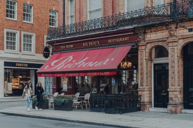 Londra, İngiltere - 5 Aralık 2020: Mayfair 'deki Richoux çay evi ve restoranı cephesi, Londra' nın batı ucunda zengin bir bölge, kadınlar geçip gidiyor, hareket bulanıklığı.