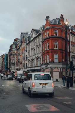 Londra, İngiltere - 5 Aralık 2020: Marylebone 'daki Wigmore Caddesi manzarası, Londra' nın şık bir yerleşim alanı, yolda beyaz taksiler, hareket bulanıklığı.
