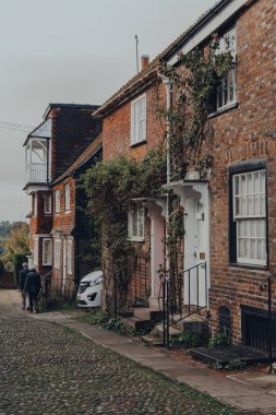 Rye, UK - October 10, 2020: Row of old houses on a street in Rye, one of the best-preserved medieval towns in East Sussex, England, people walk on the background.