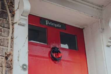Rye, UK - October 10, 2020: Close up of Petergate house name on a red door of a traditional English house in Rye, one of the best-preserved medieval towns in East Sussex, England.