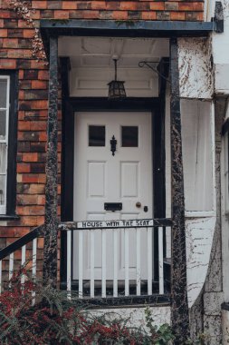 Rye, UK - October 10, 2020: White front door of old crooked House With The Seat house on Mermaid Street in Rye, one of the best-preserved medieval towns in East Sussex, England.