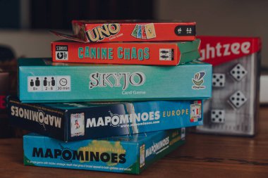 Combe St Nicholas, UK - July 25, 2020: Stack of modern and classing board games on a table. Sales of board games skyrocketed during the Coronavirus pandemic-related lockdowns.