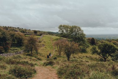 Cheddar Gorge, UK - July 26, 2020: People walking on a path on top of Cheddar Gorge, a famous limestone gorge in the Mendip Hills, near the village of Cheddar, Somerset, England.