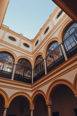 Seville, İspanya - 19 Ocak 2020: Kastilya Kralı Peter için inşa edilmiş bir kraliyet sarayı olan Sevilla 'daki Hint Adaları Kiralama Evi' nin renkli avlusunun alçak açılı görüntüsü.
