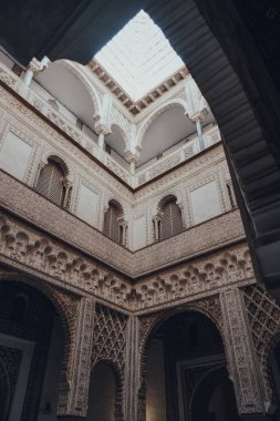Seville, İspanya - 19 Ocak 2020: Kastilya Kralı Peter için inşa edilmiş bir kraliyet sarayı olan Sevilla 'daki Mudejar Sarayı' nın Dolls Avlusundaki tavan penceresinin alçak açısı.
