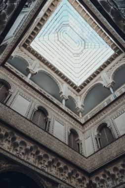 Seville, İspanya - 19 Ocak 2020: Kastilya Kralı Peter için inşa edilmiş bir kraliyet sarayı olan Sevilla 'daki Mudejar Sarayı' nın Dolls Avlusundaki tavan penceresinin alçak açısı.