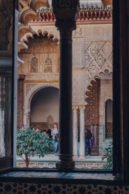 Seville, İspanya - 19 Ocak 2020: Kastilya Kralı Peter için inşa edilmiş bir kraliyet sarayı olan Sevilla Alcazar 'daki Patio de Maidens avlusunun penceresinden bakın..