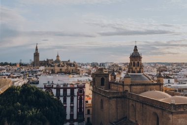 Seville, İspanya - 19 Ocak 2020: Güney İspanya 'nın Endülüs bölgesinin başkenti ve popüler bir turizm merkezi olan Seville' deki Anunciation Kilisesi, çatıları ve şehir silueti.