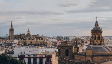Seville, İspanya - 19 Ocak 2020: Güney İspanya 'nın Endülüs bölgesinin başkenti ve popüler bir turizm merkezi olan Seville' deki Anunciation Kilisesi, çatıları ve şehir silueti.