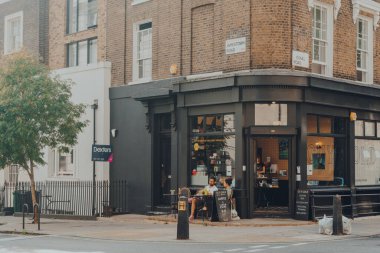 Londra, İngiltere - 12 Ağustos 2020: Londra 'nın Camden kentindeki Guy Gold kahve dükkanının açık masalarında oturan insanlar, pazar ve gece hayatı ile ünlü ve turistler arasında popüler bir bölge..