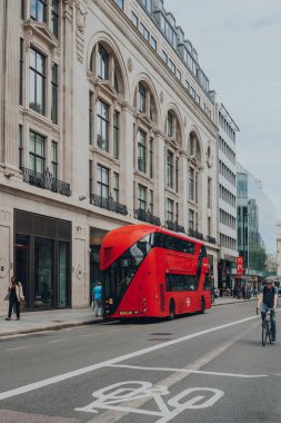 Londra, İngiltere - 26 Haziran 2021: Tottenham Court Road, Londra 'daki modern kırmızı çift katlı otobüsler. İkonik kırmızı otobüsler Londra ağı için taşımacılığın ayrılmaz bir parçasıdır.