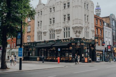 Londra, İngiltere - 26 Haziran 2021: Tottenham Court Road 'da 1730 yılında kurulan ve Tottenham Court Road, Londra' da bulunan geleneksel Viktorya Dönemi barının önünde yürüyen insanlar.