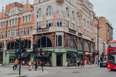 Londra, İngiltere - 26 Haziran 2021: Fitzrovia 'da restoranlar, oteller, galeriler ve eski okul barları ile bilinen çeşitli bir alan olan Fitzrovia' daki dükkanların ve restoranların önünden geçen insanlar.