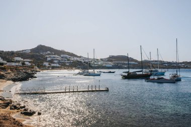 Yunanistan 'ın Mykonos, Agios Ioannis sahilindeki sahil, rıhtım ve yatların manzarası.