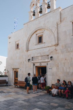 Ana Mera, Yunanistan - 24 Eylül 2019: Panagia Tourliani Manastırı 'ndaki bir kiliseye giren insanlar, Mykonos' ta 16. yüzyıldan kalma beyaz boyalı bir kilise ve manastır.