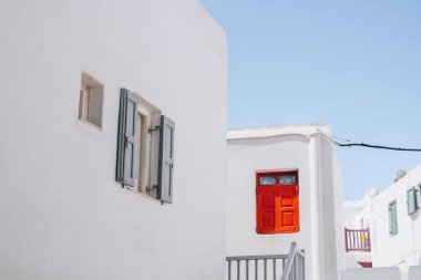 Hora (Mykonos Town), Mykonos, Yunanistan 'da kırmızı ve mavi ayrıntı içeren geleneksel beyaz boyalı evlerin manzarası.