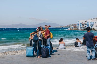 Mykonos Town, Yunanistan - 24 Eylül 2019: Adanın başkenti ve Kiklad mimarisinin en iyi örneklerinden biri olan Hora 'da (Mykonos Town olarak da bilinir) selfie çeken genç bayan turistler.