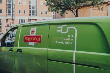 Londra, İngiltere - 03 Eylül 2021: Londra 'da bir sokakta yeşil sıfır emisyon elektrikli Kraliyet Posta Minibüsü. Kraliyet Postası aktif olarak karbon ayak izini azaltmak için elektrikli araç sayısını artırıyor.