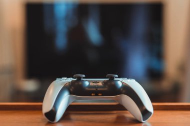 Londra, İngiltere - 25 Mayıs 2021: Playstation 5 (PS5) denetleyici düz, seçici odak içinde tablo üzerinde. Playstation 5, Sony 'nin Kasım 2020' de piyasaya sürdüğü son video oyunu konsoludur.