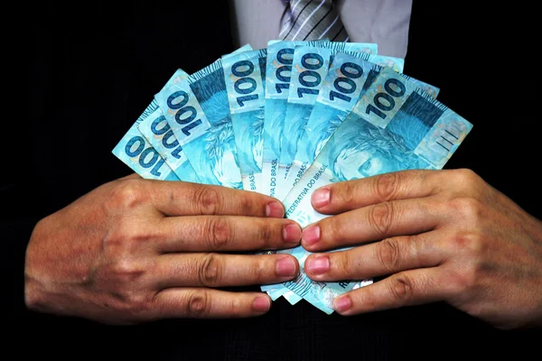 Homem de terno segurando notas de dinheiro Brasil — Fotografia de Stock