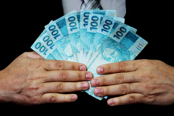 Mörk-passade mannen hålla pengar anteckningar Brasilien — Stockfoto