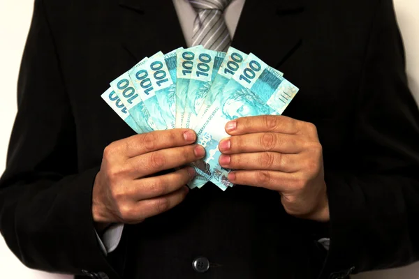 Karanlık uygun adam Brezilyalı banknotlar holding — Stok fotoğraf