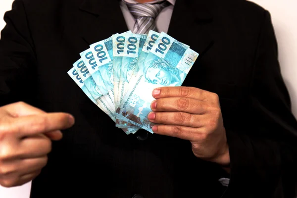 Takım elbise ve kravat Brezilyalı banknotlar tutan adam — Stok fotoğraf