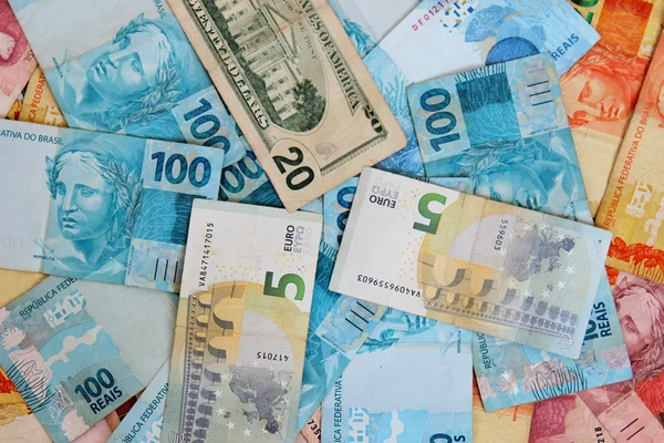 Dólar e euro misturados com dinheiro brasileiro — Fotografia de Stock