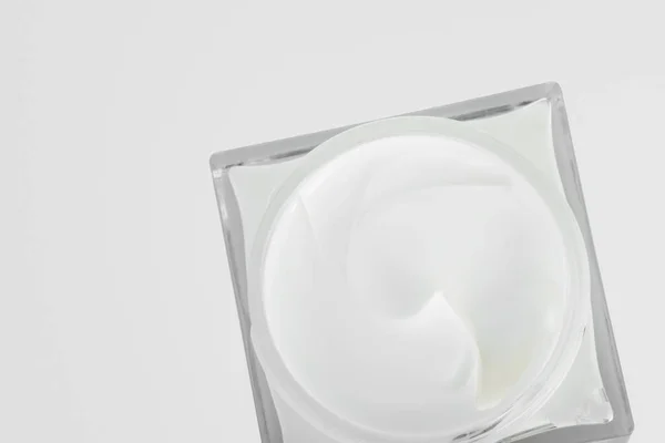 一罐奶油特写 面霜在玻璃瓶中 在灰色背景下孤立 免版税图库照片