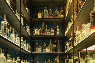 Kyiv, Ukrayna - 20 Ekim 2025: Bir bar ortamında alkollü içeceklerin tam envanterini gösteren arka plandaki çeşitli ruhlarla dolu bir içki deposunu geniş açıdan görmek.