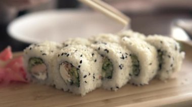 Bir ziyaretçi bambu çubuklarıyla suşi yer.. 