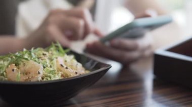 Kadınlar Japon mutfağında yemek yerken bir süre akıllı telefon kullanır.. 