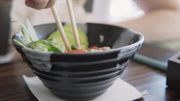 Someone eats a bowl with avocado, tomatoes, rice, spinach and chicken. — Stock Video